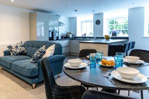 a living room with a blue couch and a table at Stylish & Contemporary 2-Bedroom House in Worksop