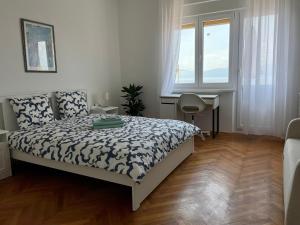 a bedroom with a bed and a desk and a window at Nona's view with balcony in Rijeka