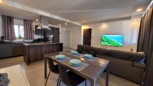sala de estar con mesa y sofá en Stylish - Modern - Large Terrace - 2 Bed - 200 M From Sea - Fully Air Con en St Paul's Bay