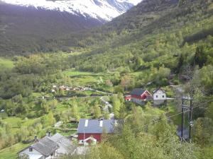 a small village in a valley with a snow covered mountain at Lunheim in Geiranger in Geiranger