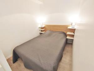 een kleine slaapkamer met een bed in een kamer bij Le Sentein, T2, centre, parking, jardin, 2 personnes in Luchon