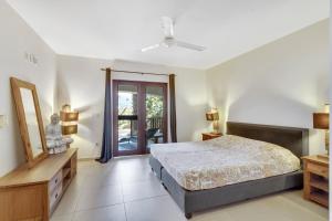 Schlafzimmer mit einem Bett und einer Tür zu einem Balkon in der Unterkunft Bonaire Apartment in Kralendijk