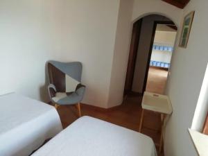 a room with a chair and a bed and a mirror at Bela Vista in Aljezur