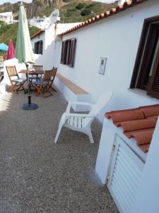 a patio with chairs and a table and umbrella at Bela Vista in Aljezur