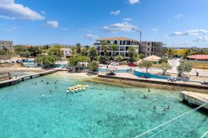 a group of people in the water at a swimming pool at Bonaire Apartment in Kralendijk