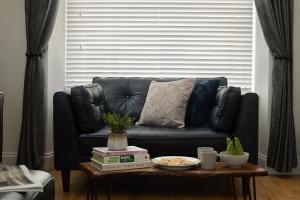 a black couch in a living room with a coffee table at Nythfa in Llanrwst +15 photos