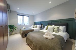 - une chambre avec 2 lits et des serviettes dans l'établissement City View Terrace, à Cambridge