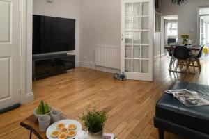 a living room with a couch and a table with food at Nythfa in Llanrwst