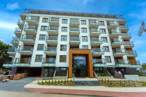 a large white building with balconies on it at Bel Mare Aqua Resort B&M in Międzyzdroje