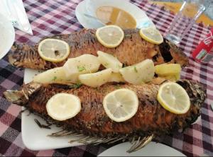 un plato de pescado con rodajas de limón en él en House Markovic, 