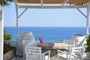 einen Tisch und Stühle mit Meerblick im Hintergrund in der Unterkunft Summer Residence in Provatas