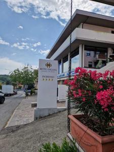 una señal frente a un edificio con flores rosas en Hotel Dogana, en San Marino