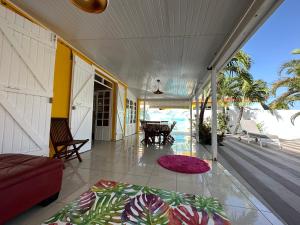 een veranda met een bank en een tapijt op de vloer bij Villa des Stars xtelx0690x07xx1415xx in Saint-François