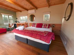 1 dormitorio con 1 cama en una habitación con techos de madera en Cloudy Creek Cottage, en South Bruny