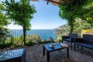 a patio with a table and chairs and a view of the ocean at Villa di lusso con piscina tra Positano e Amalfi in Conca dei Marini