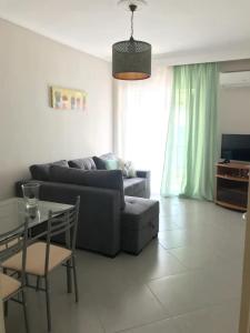 a living room with a couch and a table at Elena's Beach house in Nea Irakleia