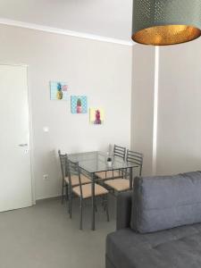 a dining room with a glass table and chairs at Elena's Beach house in Nea Irakleia