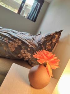 a vase with a flower in it on a table at Modern and comfortable apartment in attractive neighborhood in Stavanger