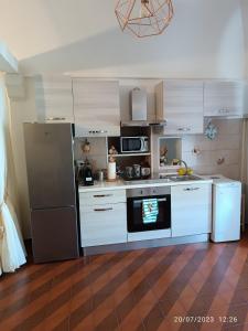 eine Küche mit weißen Schränken und einem schwarzen Kühlschrank in der Unterkunft Locazione turistica La vecchia arcata in Noci