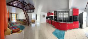 een keuken met rode kasten en een woonkamer bij Villa des Stars xtelx0690x07xx1415xx in Saint-François