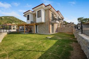 a house with a lawn in front of it at Bal Butik Otel in Datca