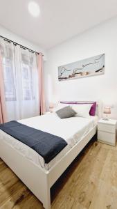 1 dormitorio con 1 cama blanca grande y ventana en OTEIZA, en Madrid