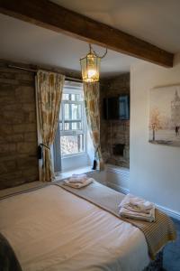 a bedroom with a large bed with a window at The White Horse Inn in Holmfirth