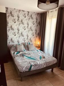 1 cama en un dormitorio con pared en LE MONICA en Narbonne