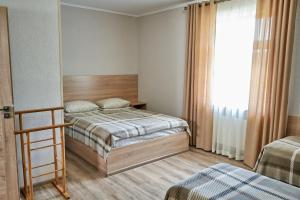 ein kleines Schlafzimmer mit zwei Betten und einem Fenster in der Unterkunft Каприз in Kamjanez-Podilskyj