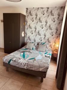 Bett in einem Zimmer mit einer Wand in der Unterkunft LE MONICA in Narbonne