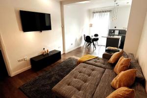 a living room with a couch and a flat screen tv at Luxury, Spacious 1 Bedroom Flat in South Norwood