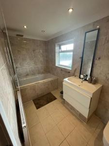 La salle de bains est pourvue d'une baignoire, d'un lavabo et d'une baignoire. dans l'établissement Luxury, Spacious 1 Bedroom Flat, à South Norwood