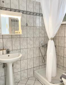 a bathroom with a sink and a shower curtain at Villa Elva in Ammoudia +92 photos