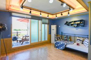 ein Kinderzimmer mit einem Bett und einem großen Fenster in der Unterkunft Suncheon Bay Healing Pension in Suncheon