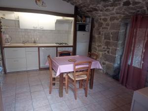 cocina con mesa y sillas en una habitación en Gîte le Petit Riou, en Sainte-Marguerite-Lafigère