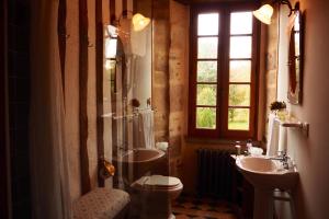 a bathroom with a sink and a toilet and a window at Le Château Isigny un joyau caché et secret près du Mont Saint-Michel en Normandie aux portes de la Bretagne in Isigny-le-Buat