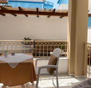 a patio with a table and chairs on a balcony at Villa Elva in Ammoudia