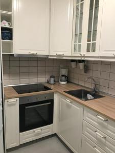 a kitchen with white cabinets and a sink at Elena's Beach house in Nea Irakleia