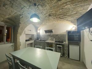 a kitchen with a table and a stone wall at Casa degli ulivi in Cuglieri