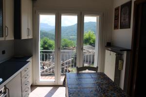 una cocina con mesa y una gran puerta corredera de cristal en Relax and apartment, en SantʼAgata Feltria