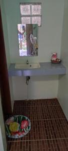 a bathroom with a sink and a mirror at ALFA Garden Lodge in El Nido