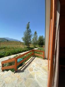 un banco de madera en un porche con vistas a un campo en Hotel Skiatori 2, en Kukës