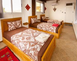 a room with three beds in a room at The Rina Hostel in Agadir