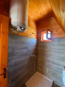 y baño con ducha en el techo de madera. en Hotel Skiatori 2, en Kukës