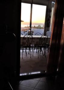 widok na stół i krzesła przez drzwi w obiekcie casa vacanze calasetta w mieście Calasetta