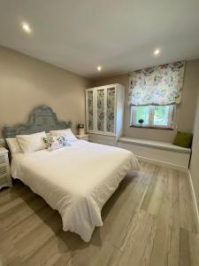 - une chambre avec un grand lit blanc et 2 fenêtres dans l'établissement La Goleta, à Avilés