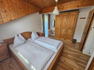 a bedroom with a large white bed with wooden floors at Haus Beim Seppl in Naturno