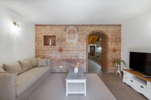 a living room with a couch and a brick wall at Casa do Forno (Vale Luis Neto-Retiro do Caldeirão) in Loulé