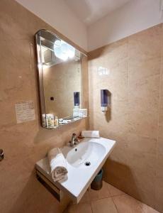 ein Bad mit einem Waschbecken und einem Spiegel in der Unterkunft Hotel Ristorante Mariuccia Varese in Varese