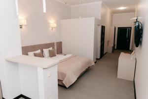 a white bedroom with a bed and a desk at СПА Готель СВ in Khmelnytskyi